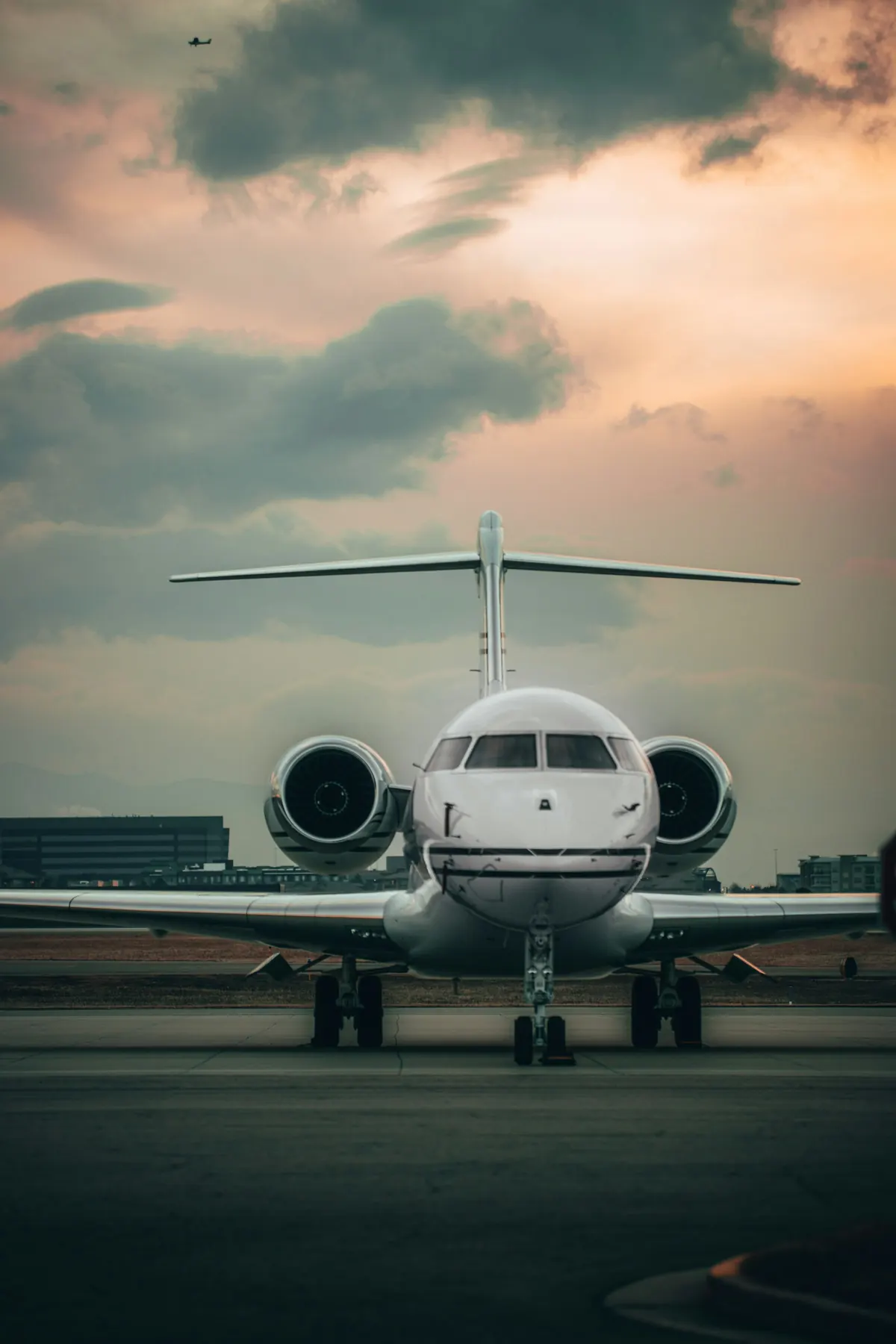 Super-midsize jet facing the camera on an evening ramp